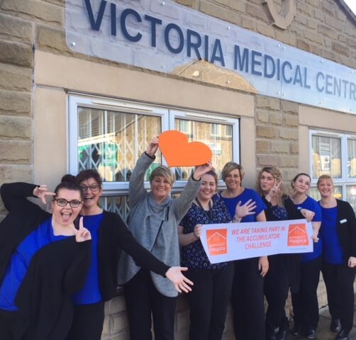 Photo of the staff from Victoria Medical centre holding a banner in support of the accumulator challenge